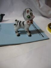 Baby zebra figurine has flowers and bell around neck marked Japen in red 2.5