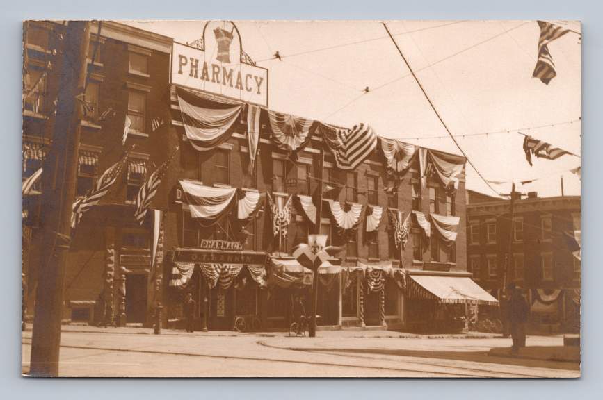 OT Larkin Pharmacy w Patriotic Decorations RPPC Plattsburgh New York Photo 1910s